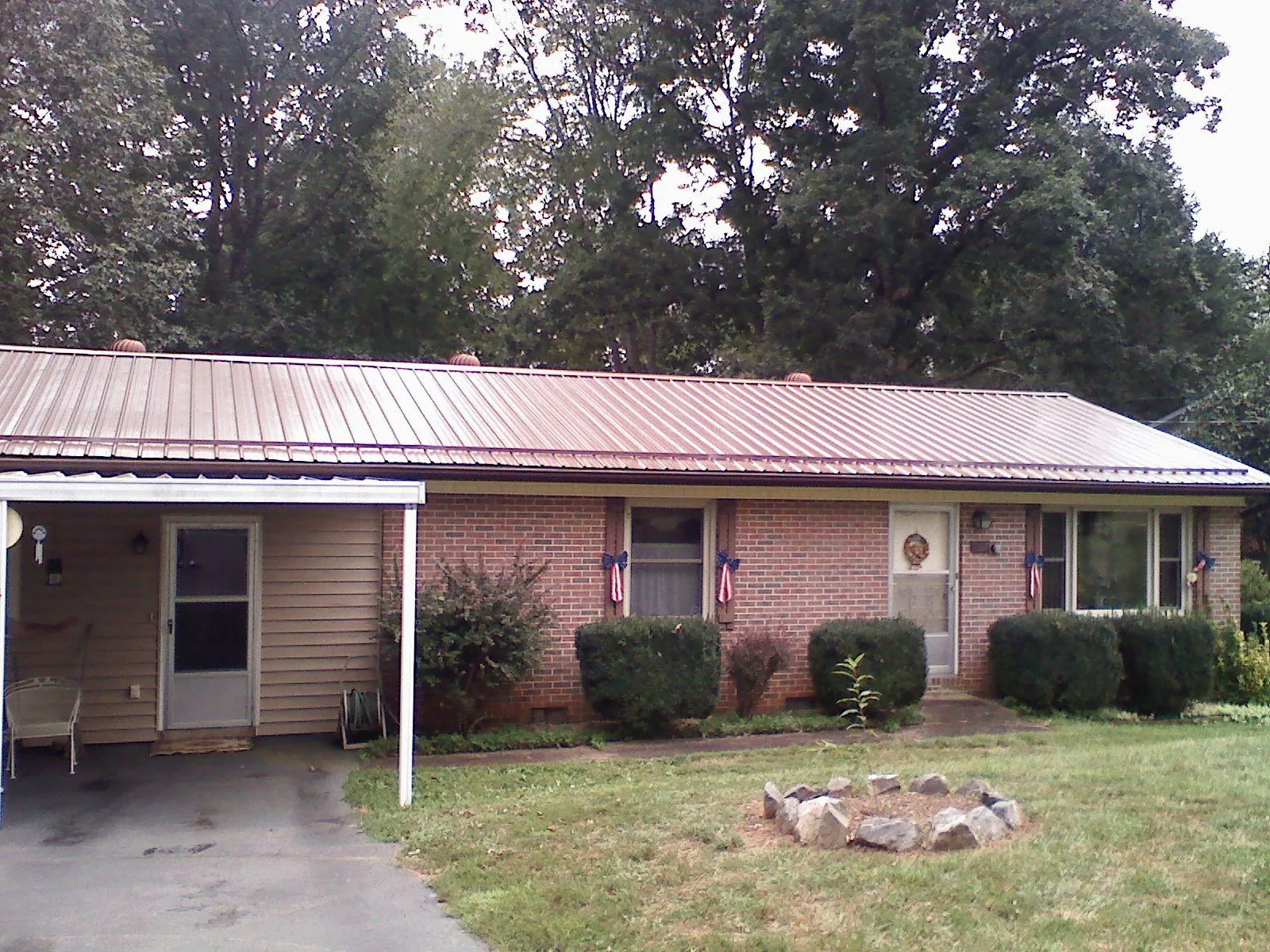 Bronze metal roof and carport on a brick ranch home — Roof Repair work by our crew in Oakville